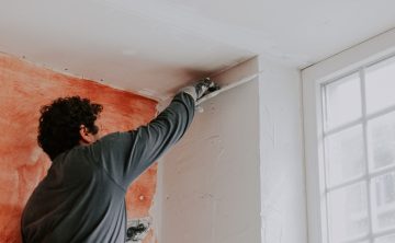 a-caucasian-young-guy-smoothes-fresh-putty-with-a-2025-03-06-19-14-15-utc