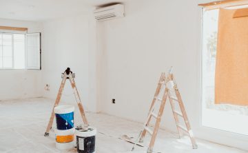 ladders and pots on white room at construction site. Painting walls. Home improvement, renovation